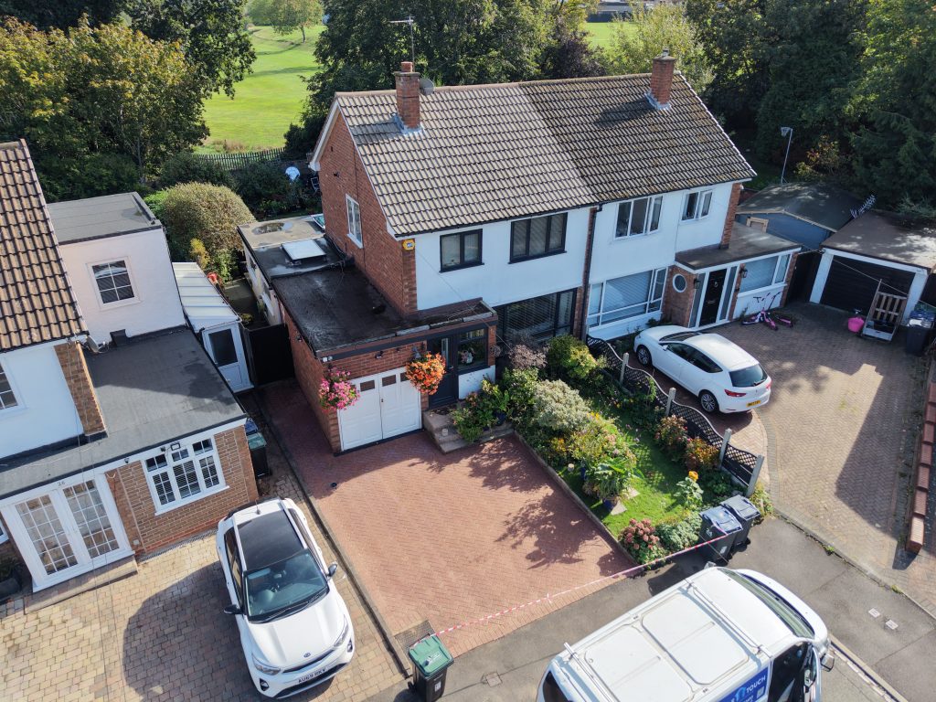Aerial view of a semi-detached home with a cleaned tiled roof